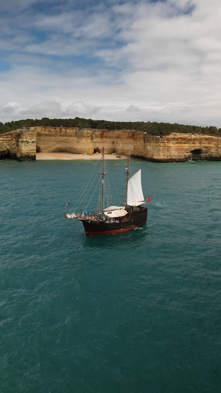 Private sailing vessel anchored near coastal cliffs
